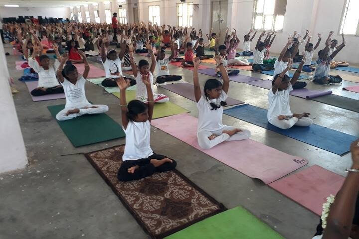 Students in a mass yoga session in a hall