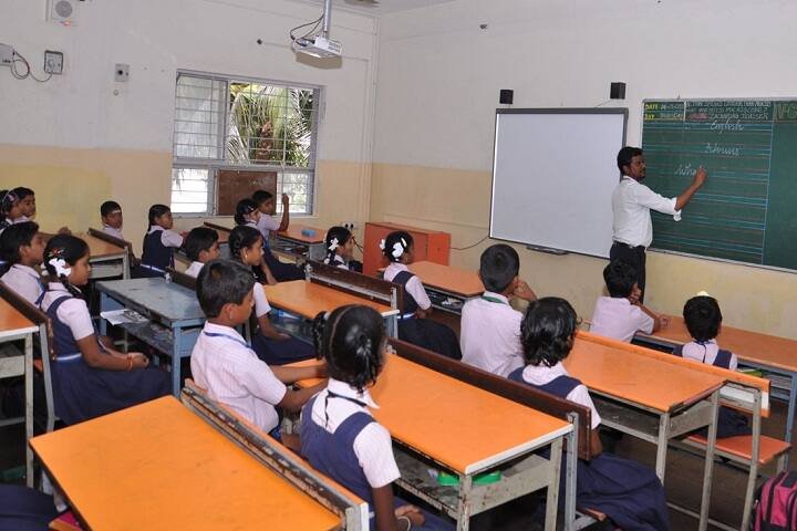 Teacher at the board in a Vidya Saaket classroom with a projector